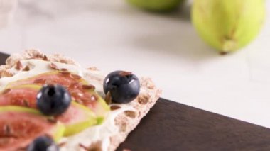 Kanepe veya crostini ile krem peynir ve taze incir dilimleri bir ahşap tahta üzerinde buğday crispread. Lezzetli meze bir aperatif ideal.
