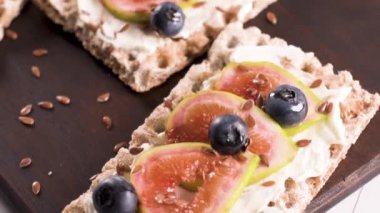 Kanepe veya crostini ile krem peynir ve taze incir dilimleri bir ahşap tahta üzerinde buğday crispread. Lezzetli meze bir aperatif ideal.