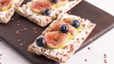 Kanepe veya crostini ile krem peynir ve taze incir dilimleri bir ahşap tahta üzerinde buğday crispread. Lezzetli meze bir aperatif ideal.