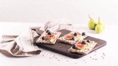 Kanepe veya crostini ile krem peynir ve taze incir dilimleri bir ahşap tahta üzerinde buğday crispread. Lezzetli meze bir aperatif ideal.