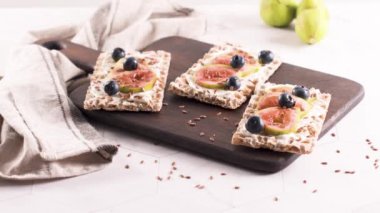 Kanepe veya crostini ile krem peynir ve taze incir dilimleri bir ahşap tahta üzerinde buğday crispread. Lezzetli meze bir aperatif ideal.