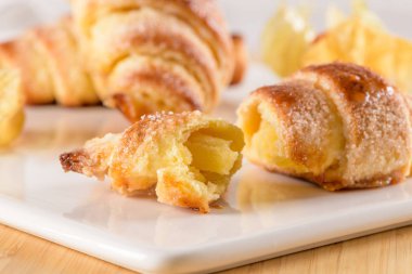 Küçük ayçöreği beyaz seramik tepsi içinde physalis meyve, ahşap masa üstüne ev yapımı kekler.