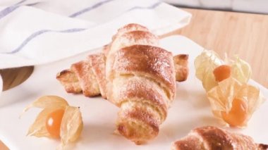 Küçük ayçöreği beyaz seramik tepsi içinde physalis meyve, ahşap masa üstüne ev yapımı kekler.