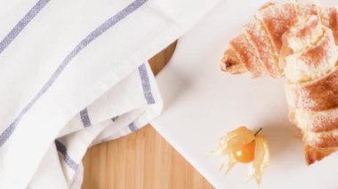 Küçük ayçöreği beyaz seramik tepsi içinde physalis meyve, ahşap masa üstüne ev yapımı kekler.