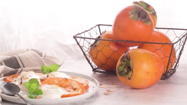 ヨーグルトとアーモンド スライスのパーシモン 明るい背景に健康食品のコンセプト — ストック動画