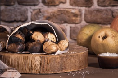 Kavrulmuş kestane rustik mutfak tezgah üzerinde bir kağıt koni.