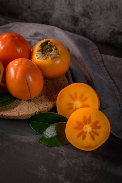 Ripe Persimmon Fruits Cork Plate Dark Kitchen Counter Top — Stock Photo, Image