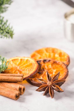 Dilim kurutulmuş portakal ve mermer yüzeyindeki çam dalı.