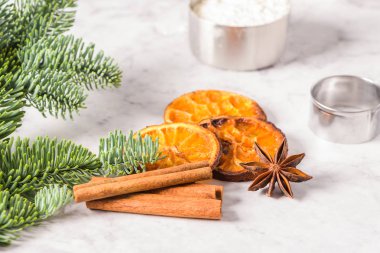 Dilim kurutulmuş portakal ve mermer yüzeyindeki çam dalı.