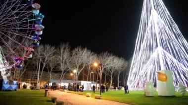 Aveiro, Portekiz - yaklaşık Aralık 2018: Fonte Nova'nın bahçe Noel pazarı ve geceleri Ria de Aveiro yakınındaki renkli dönme dolap ile.