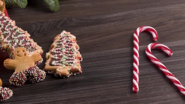 圣诞节假期的背景与姜饼饼干 糖果棒和常青树在木桌上 圣诞节和新年的食物 圣诞节装饰和糖果在木头背景 — 图库视频影像
