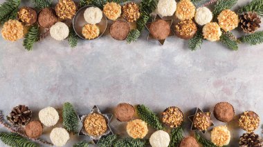 Ev yapımı çikolata truffles toz kakao, Hindistan cevizi, ceviz dekoratif Noel çerçevesinin üzerine gri doku arka plan olarak. Üstten görünüm, kopya alanı.