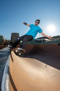 kaykaycı yerel skatepark günbatımında Grind'de üzerinde.