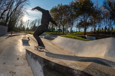 kaykaycı yerel skatepark günbatımında Grind'de üzerinde.