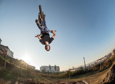 BMX bisiklet ters parende atlamak bir toprak yolda.