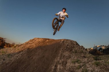 BMX Bike jump over a dirt trail on a dirt track. clipart