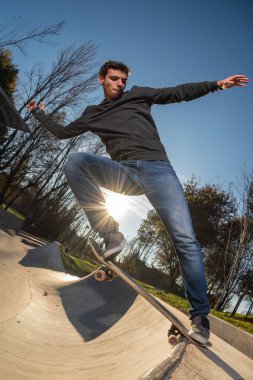 Kaykaycı tarih itibariyle yerel skatepark günbatımında bir kuyruk durak.