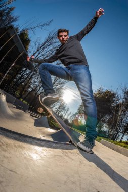 Kaykaycı tarih itibariyle yerel skatepark günbatımında bir kuyruk durak.