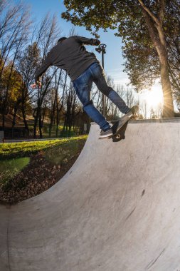Kaykaycı Rock n roll yerel skatepark, gün batımında.