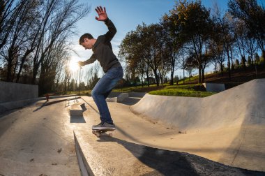 kaykaycı yerel skatepark günbatımında Grind'de üzerinde.