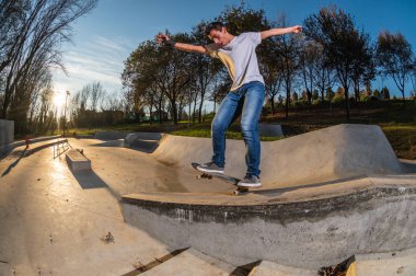 kaykaycı yerel skatepark günbatımında Grind'de üzerinde.