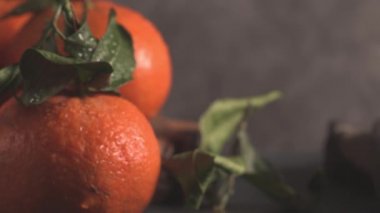 Taze mandarin portakal veya mandalina dokulu koyu arka plan üzerinde yaprakları ile