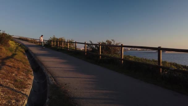 Junge Skateboarder Freizeitkleidung Cruisen Bei Sonnenuntergang Fuß Fluss Entlang — Stockvideo