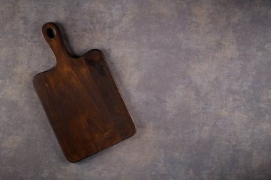 Ahşap kesme tahtası üstten görünüm eski taş tezgah üzerinde.