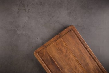 Ahşap kesme tahtası üstten görünüm eski taş tezgah üzerinde.