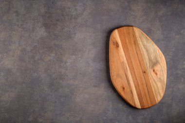 Ahşap kesme tahtası üstten görünüm eski taş tezgah üzerinde.