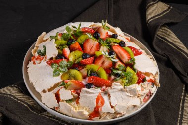 Taze yaban mersini, çilek ve kivi ile Pavlova pasta.