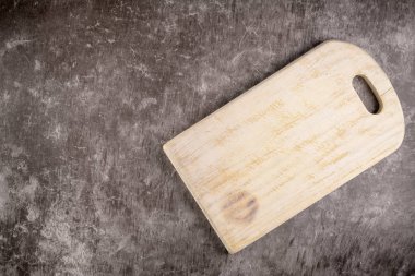 Ahşap kesme tahtası üstten görünüm eski taş tezgah üzerinde.