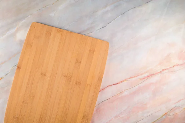 Tabla de cortar de madera sobre un fondo de mármol gris — Foto de Stock