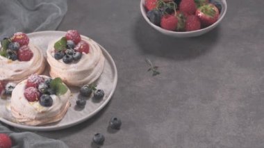 Taze raspbberries ve yaban mersini ile küçük pavlova kek.