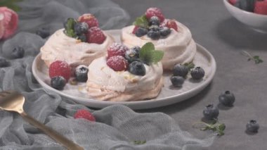 Taze raspbberries ve yaban mersini ile küçük pavlova kek.
