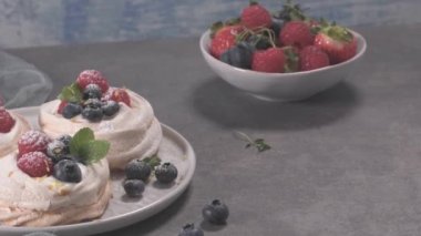 Taze raspbberries ve yaban mersini ile küçük pavlova kek.