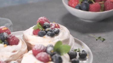 Taze raspbberries ve yaban mersini ile küçük pavlova kek.