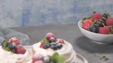 Taze raspbberries ve yaban mersini ile küçük pavlova kek.