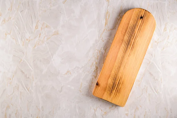 Wooden cutting board on a gray marble background — Stock Photo, Image