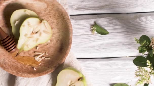 木製のテーブルの上に蜂蜜とナッツとおいしい梨 — ストック動画