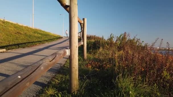 Gün Batımı Üzerinde Nehir Kenarında Yaya Yürüyüşü Aşağı Seyir Skateboarder — Stok video