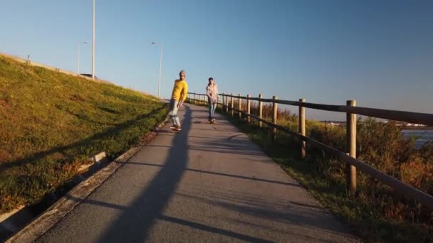 Gün Batımı Üzerinde Nehir Kenarında Yaya Yürüyüşü Aşağı Seyir Skateboarders — Stok video