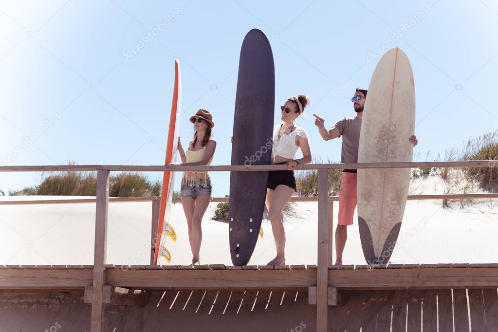 Boys and girls teen surfers with surfboards