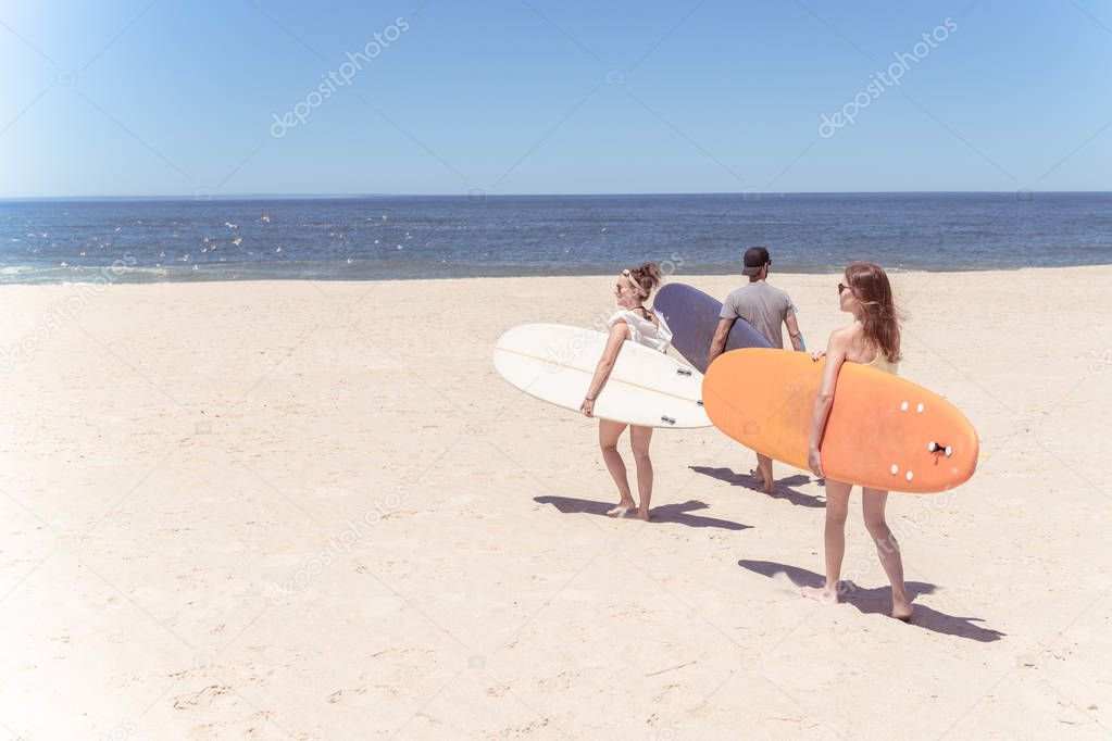 Boys and girls teen surfers with surfboards