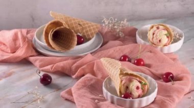 Dondurma ve kiraz meyveli geleneksel waffle konileri mermer taş yüzeyde.