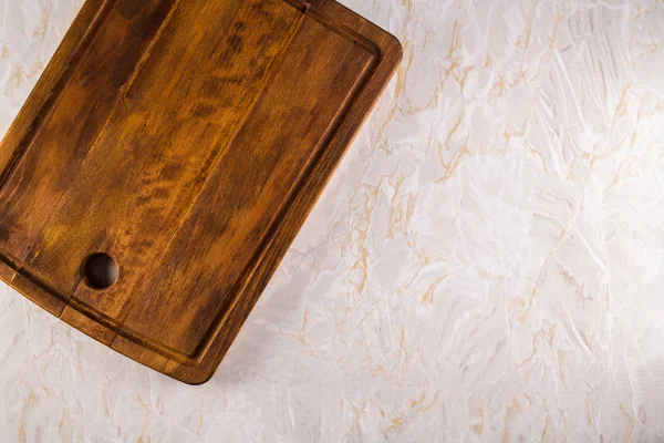 Placa de corte de madeira em um fundo de mármore cinza — Fotografia de Stock