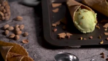 Siyah bir arka planda waffle konileri fıstık dondurması topları.