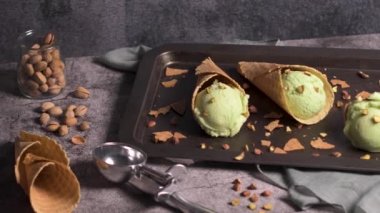 Siyah bir arka planda waffle konileri fıstık dondurması topları.