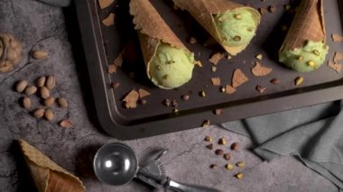 Siyah bir arka planda waffle konileri fıstık dondurması topları.