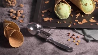 Siyah bir arka planda waffle konileri fıstık dondurması topları.